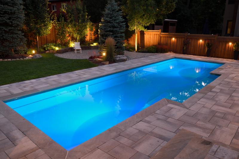 builders and contractors Pool in evening with lights and interlocking brick